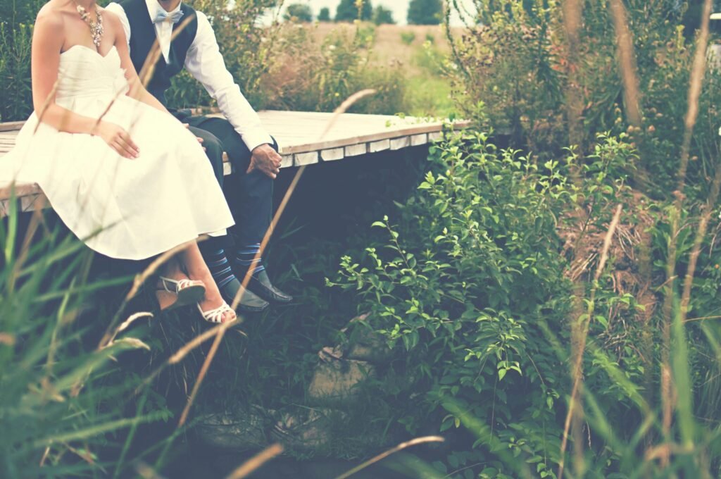 Close up of bride and grooms feet sitting on a wooden walkway
