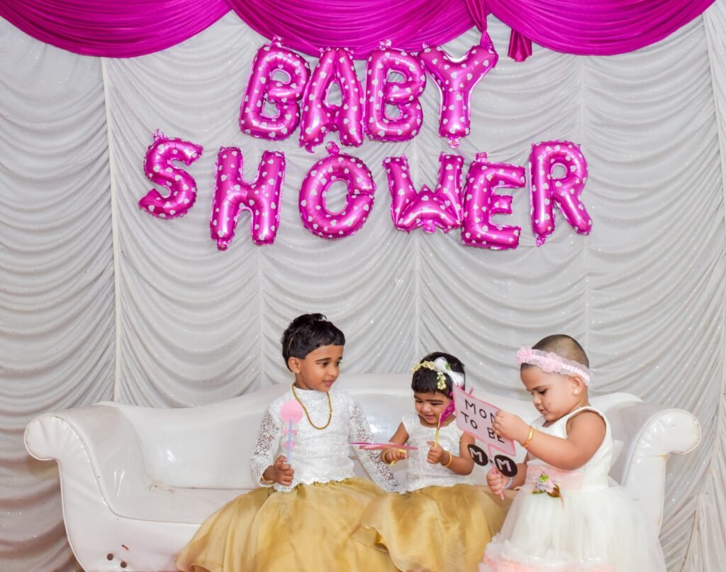 Pink baby shower sign and kids