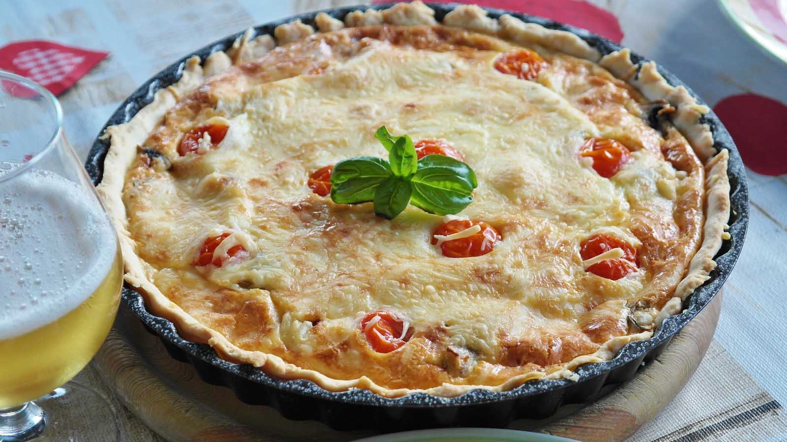 An authentic Quiche Lorraine showing the savory custard filling with lardons in a flaky pastry crust