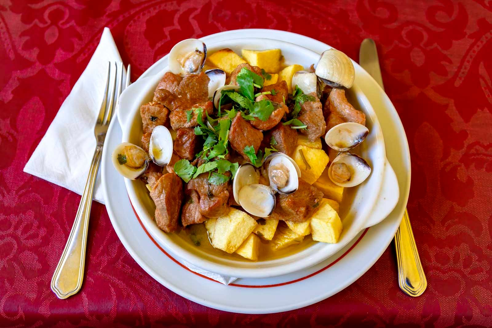 A traditional Portuguese dish of Carne de Porco à Alentejana, featuring marinated pork and fresh clams.