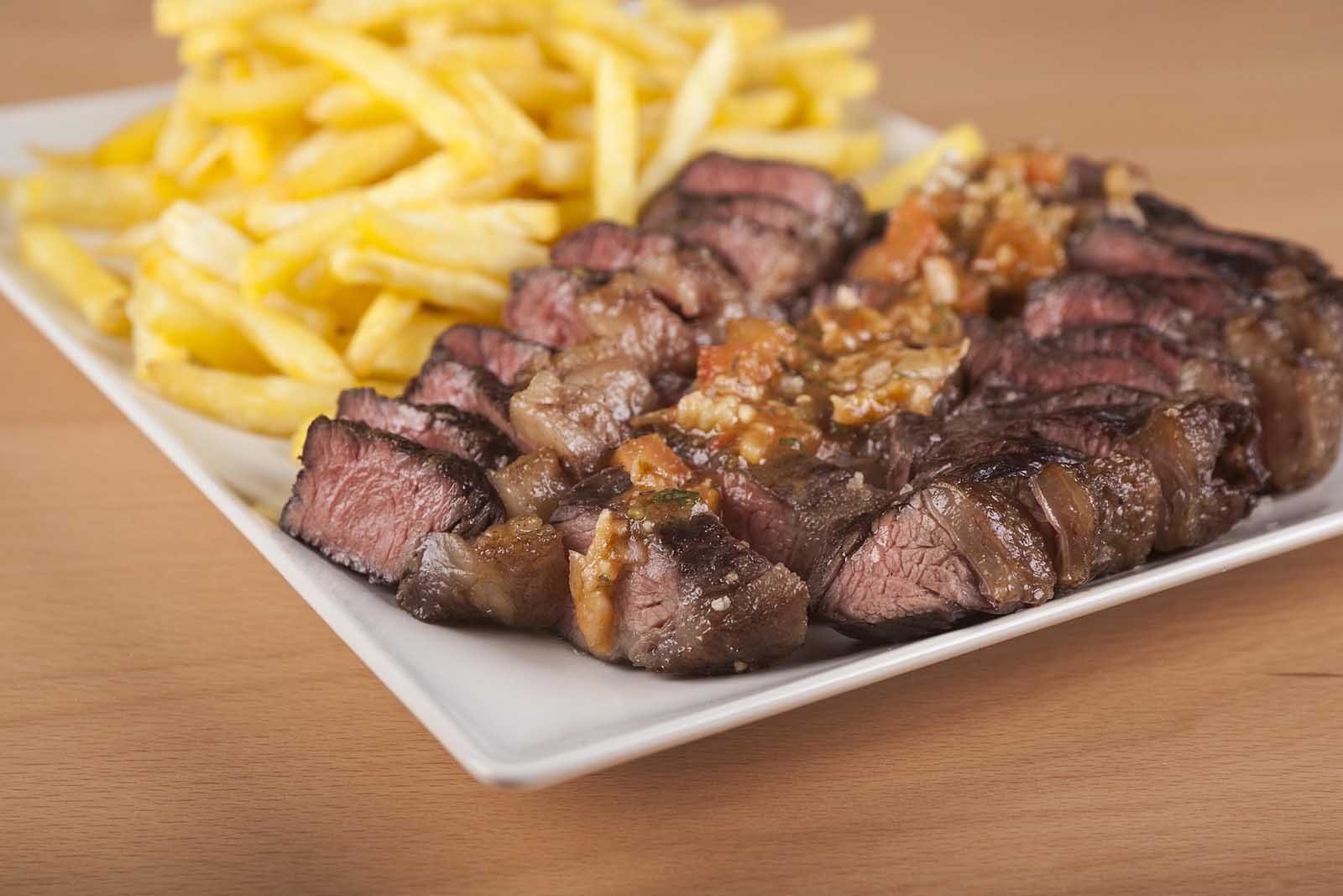Slices of juicy, grilled Picanha steak, served with french fries.  a popular Brazilian-style barbecue dish in Portugal.