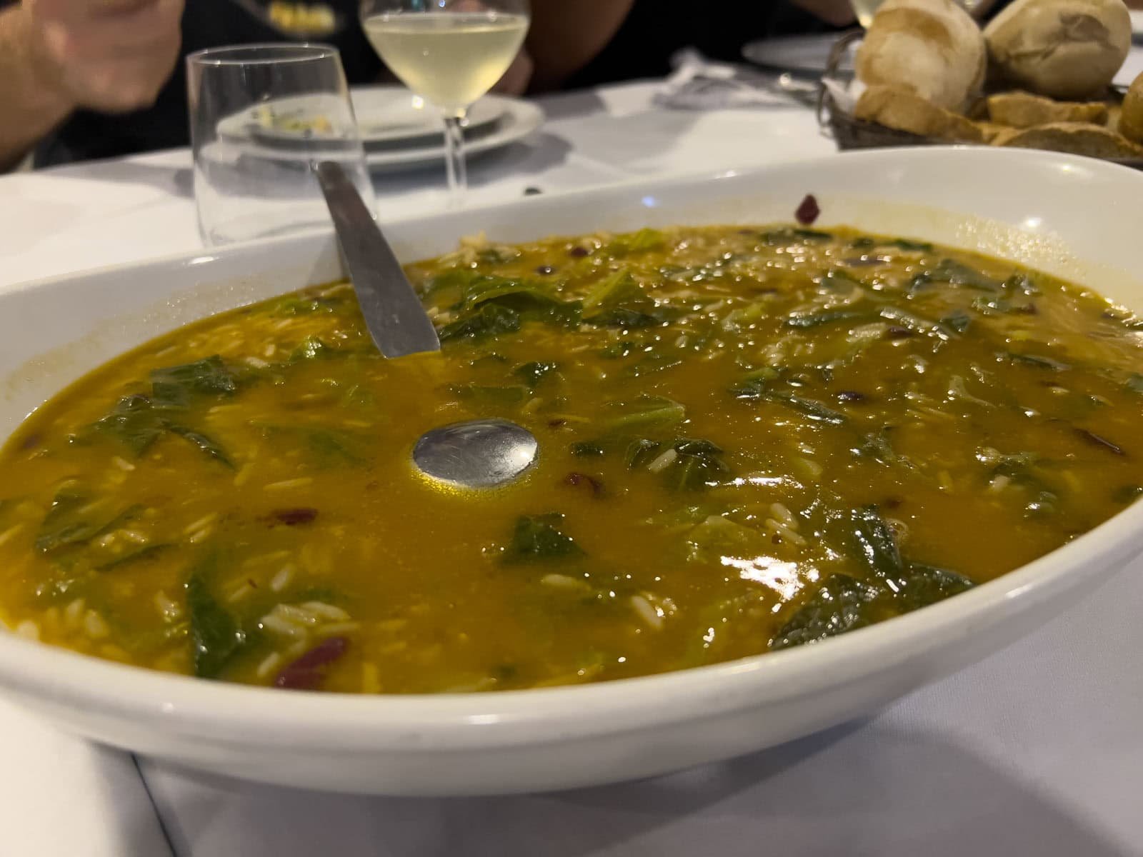 A warm bowl of Caldo Verde, a traditional Portuguese green soup with slices of chouriço sausage.