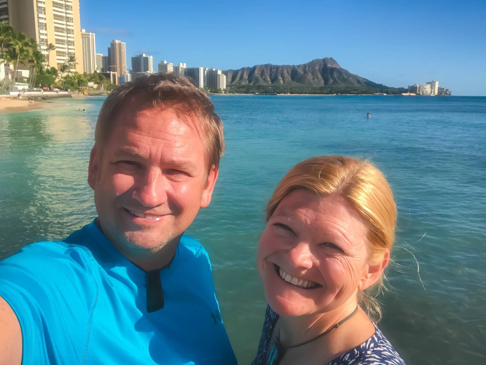 Dave and Deb of The Planet D smiling on a beach in Hawaii, ready for an adventure.