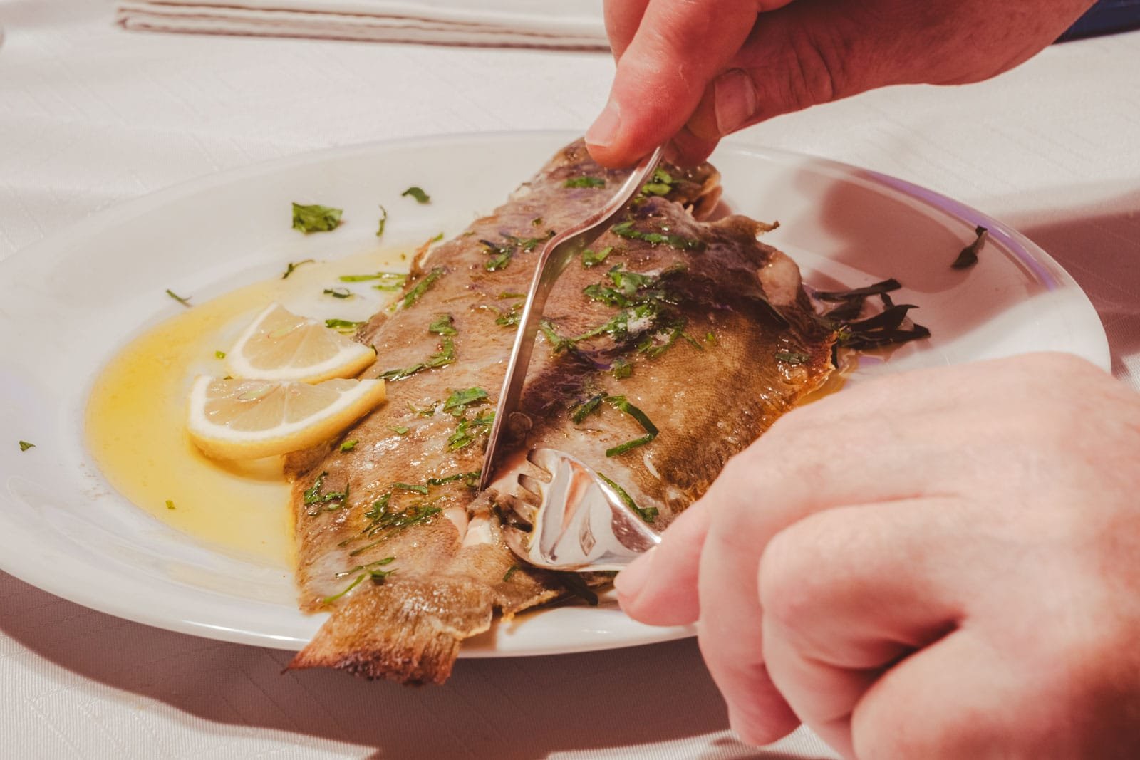 Digging into an elegant plate of Sole Meunière, a whole Dover sole pan-fried in brown butter with lemon and parsley